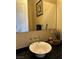 Well-lit bathroom featuring a vessel sink, modern faucet, and sleek black countertop at 4738 Laurel Canyon St, Las Vegas, NV 89129