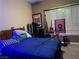 Well-lit bedroom featuring a blue comforter, window with blinds, and decorative wall art at 4738 Laurel Canyon St, Las Vegas, NV 89129