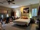 Large bedroom with a golden bed frame, ceiling fan, and natural light from two windows at 4738 Laurel Canyon St, Las Vegas, NV 89129