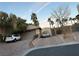 Charming single-story house with a paved driveway, mature trees, a garage, and a parked white car at 4738 Laurel Canyon St, Las Vegas, NV 89129