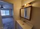 Bright bathroom vanity with a framed mirror and views to an open bedroom area with big windows at 4795 Via San Andros, Las Vegas, NV 89103
