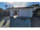 Single-story home with a two-car garage, white exterior, and desert landscaping at 4795 Via San Andros, Las Vegas, NV 89103