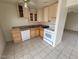 Functional kitchen with tiled floors, light wood cabinets, and white appliances at 4795 Via San Andros, Las Vegas, NV 89103