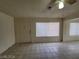 Open-concept living room with tile flooring, large windows, and a ceiling fan at 4795 Via San Andros, Las Vegas, NV 89103
