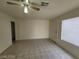 Open-concept living room with tile flooring, large windows, and a ceiling fan at 4795 Via San Andros, Las Vegas, NV 89103