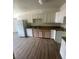 Functional kitchen with white cabinets, granite countertops, modern appliances and wood-look floors at 5128 Forrest Hills Ln, Las Vegas, NV 89108