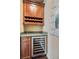 Convenient wet bar featuring custom cabinets, granite countertop, and a wine refrigerator at 52 Cascade Lake St, Las Vegas, NV 89148