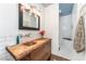 Well-lit bathroom with a distinctive wooden vanity, copper sink, and walk-in tiled shower at 5221 Holmby Ave, Las Vegas, NV 89146