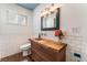 Charming bathroom showcasing a custom wood vanity, subway tile walls, and modern lighting at 5221 Holmby Ave, Las Vegas, NV 89146