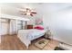 Bright bedroom featuring wood floors, ceiling fan, and large closets with curtain doors at 5221 Holmby Ave, Las Vegas, NV 89146