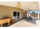Charming covered patio with hanging lights, outdoor furniture, and a convenient sliding glass door at 5221 Holmby Ave, Las Vegas, NV 89146