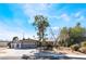 Charming single-story home with an attached garage and mature trees in a spacious front yard at 5221 Holmby Ave, Las Vegas, NV 89146