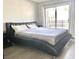 Modern bedroom featuring a large bed, sliding glass door, wood floors, and neutral wall color at 6250 W Flamingo Rd # 103, Las Vegas, NV 89103