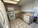 Kitchen featuring tile floors, light wood cabinets, and white appliances at 6250 W Flamingo Rd # 157, Las Vegas, NV 89103