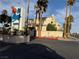 Exterior shot of the community sign, with palm trees and surrounding lush landscaping at 6250 W Flamingo Rd # 157, Las Vegas, NV 89103