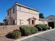 Beige stucco two-story home with a red door and desert landscaping in front at 70 Belle Essence Ave, Las Vegas, NV 89123