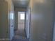 Well-lit hallway featuring neutral paint and carpet leading to a bedroom at 70 Belle Essence Ave, Las Vegas, NV 89123