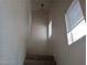 A carpeted stairwell with natural light from windows at 70 Belle Essence Ave, Las Vegas, NV 89123