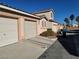 Exterior view of townhomes, showcasing private garages, landscaping, and street view at 70 Belle Essence Ave, Las Vegas, NV 89123