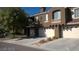 Modern townhome showcasing multi-car garage with a desert landscape and private balcony at 7290 Sheared Cliff Ln # 102, Las Vegas, NV 89149