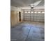 An empty garage features a large rolling door, cabinetry, and concrete flooring at 7290 Sheared Cliff Ln # 102, Las Vegas, NV 89149