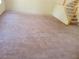 A large living room features neutral carpet and access to the staircase at 7290 Sheared Cliff Ln # 102, Las Vegas, NV 89149