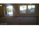 Bright living room features plush carpet, abundant natural light, and convenient staircase access at 7290 Sheared Cliff Ln # 102, Las Vegas, NV 89149