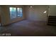Bright living room features plush carpet, abundant natural light, and convenient staircase access at 7290 Sheared Cliff Ln # 102, Las Vegas, NV 89149
