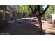 Exterior of townhouse with landscaped yard including stones and trees at 7290 Sheared Cliff Ln # 102, Las Vegas, NV 89149