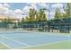 Well-maintained tennis court with professional surfacing, lighting, and shaded seating area at 7745 Fruit Dove St, North Las Vegas, NV 89084