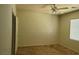 A bright bedroom with neutral carpet, a ceiling fan, and a large window for natural light at 8324 W Charleston Blvd # 2033, Las Vegas, NV 89117