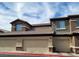 View of garage doors of condos with beige paint and stone accents at 8324 W Charleston Blvd # 2033, Las Vegas, NV 89117