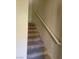 Carpeted staircase with white handrail leads to the upper level of the home at 8324 W Charleston Blvd # 2033, Las Vegas, NV 89117