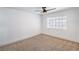 Simple bedroom featuring neutral carpet, ceiling fan, and a window at 8469 Sewards Bluff Ave, Las Vegas, NV 89129