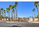 Community entrance with a gate, lush palm trees, and mountain views at 8469 Sewards Bluff Ave, Las Vegas, NV 89129