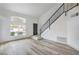 Bright living room with hardwood flooring, staircase, and large window letting in natural light at 8469 Sewards Bluff Ave, Las Vegas, NV 89129