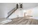 Spacious living room featuring hardwood floors, stairway, and view into updated kitchen space at 8469 Sewards Bluff Ave, Las Vegas, NV 89129