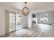Bright living room features sliding glass doors, wood floors, and modern light fixture at 8469 Sewards Bluff Ave, Las Vegas, NV 89129