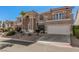 Stately two-story home with a three-car garage, balcony, and desert landscaping at 8809 Barium Rock Ave, Las Vegas, NV 89143