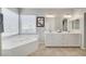 Bathroom featuring a soaking tub, double sinks, and neutral walls and floors at 9012 Old River Ave, Las Vegas, NV 89149