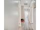 Neutral hallway with wood-look flooring, doors, and view into the playroom at 9012 Old River Ave, Las Vegas, NV 89149