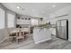 Open kitchen with white cabinets, granite counters and gray laminate floors at 9012 Old River Ave, Las Vegas, NV 89149