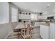 Bright eat-in kitchen featuring gray laminate floors, granite countertops, and white cabinets at 9012 Old River Ave, Las Vegas, NV 89149
