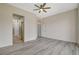 Neutral bedroom featuring light wood floors, ceiling fan, with a doorway leading to a luxurious bathroom at 10100 Folsom Dr, Las Vegas, NV 89134