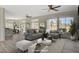 Staged living room showcases a comfortable gray sectional, modern decor, and scenic outdoor views from large windows at 10100 Folsom Dr, Las Vegas, NV 89134