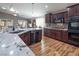 Open-concept kitchen featuring granite countertops, dark cabinets, and stainless appliances at 1028 Bonitos Suenos St, Las Vegas, NV 89138