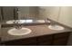 Bathroom featuring dual sinks, ample counter space, and modern faucets at 10371 Calypso Cave St, Las Vegas, NV 89141