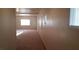 Hallway with neutral-colored walls and carpet, featuring multiple windows for natural light at 10371 Calypso Cave St, Las Vegas, NV 89141