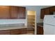 Kitchen features granite countertops, wooden cabinets, a pantry, and a white refrigerator at 10371 Calypso Cave St, Las Vegas, NV 89141
