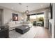 Bright living room with modern decor, comfortable seating, and sliding glass doors to the patio at 12310 Tudor Arch Dr, Las Vegas, NV 89138